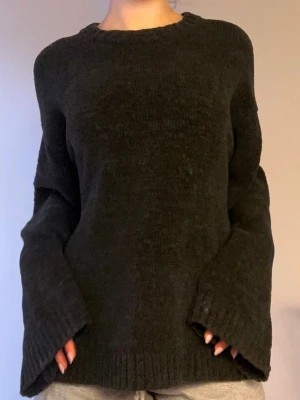 Svart Arket oversized stickad tröja - Mysig svart stickad tröja med oversized passform och vida ärmar. Tröjan har rund halsringning och ribbade muddar vid ärmslut och nederkant. Perfekt för lager på lager och en avslappnad look.
