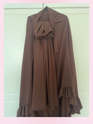 Brun khimar med volangkant + brun långkjol  - Pris går diskutera 💗Säljer en brun khimar med volangkant nedtill och vid ärmsluten. Modellen är vid och täckande med tillhörande matchande scrunchie. Materialet ser ut att vara mjukt och fallande, troligen polyester eller viskos. Perfekt för dig som vill ha en modest och stilren look.+ Tillkommer en lång tjol som syns i första bilden !💓Har fler abayas och khimar o liknande om du kollar in i min profil