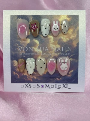 BabyMiffy (M); Short Almond - Handgjorda press-on naglar i mixade färger som rosa, vitt, cateyeguld och svart. Motiven inkluderar gulliga (Miffy) kaniner, hjärtan, stjärnor och prickar. Några naglar har texten 'baby' och 3D-detaljer. Naglarna har en kort almondform och är perfekta för dig som vill ha en unik och lekfull look.M: 16 mm, 12 mm, 12,5 mm, 11,5 mm, 10 mm