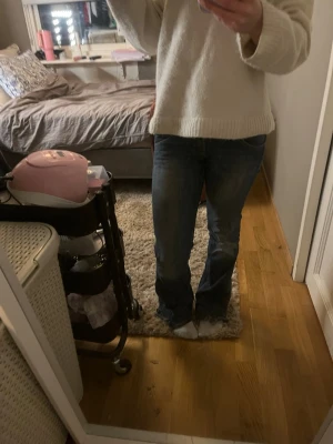 Blå bootcut jeans med klassisk tvätt - Säljer ett par blå bootcut jeans med klassisk tvätt och lätt slitning. Jeansen har normal midja och fem fickor. Passar perfekt till en avslappnad stil och är tillverkade i ett mjukt denimtyg som ger skön stretch och bra passform.