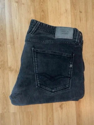 Replay Anbass jeans  - Replay Anbass jeans i grå tvätt med kontrastmönser. OBS jeans L storlek saknas, men jag skulle uppskatta till L32 - men utgå efter mått. Midja 44cm, längd 103cm. OBS jeansen har defekter! Hål vid sidan av vänster ben, hål baktill - se bilder. JAG SKICKAR EJ FLER BILDER NÄR JAG BÄR JEANSEN! för bättre inblick i passformen rekommenderar jag att googla på modellnamnet. För storleksguide kolla måtten noggrant då jeansen alltid kan vara uppsydda heller krympta och jag ej tar emot returer :) 1,24