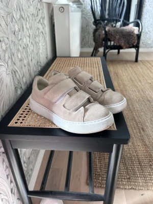 Beige sneakers med kardborreband - Stilrena beige sneakers med tre breda kardborreband och vit sula. Använda fåtal gånger, köpta för ca 2000kr🥰