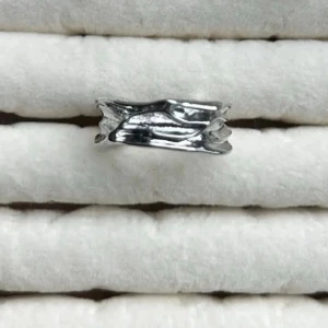 Silvrig ring med organisk form - Unik silvrig ring med en organisk, vågig design som ger ett modernt och konstnärligt intryck. Ringen har en blank yta och är tillverkad i rostfritt . Perfekt för dig som gillar statement-smycken och vill sticka ut.