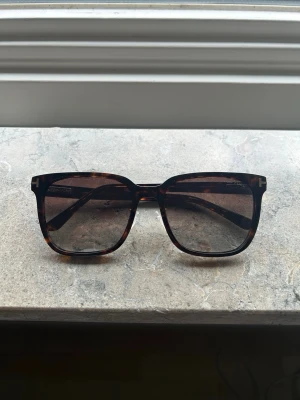 Tom Ford solglasögon sköldpaddsfärgad TF891-K bruna gradientglas - Tom Ford solglasögon i klassisk sköldpaddsfärgad båge med bruna gradientglas. Modell TF891-K (52N), storlek 59-19-150.  Köpta på flygplats och endast använda några få gånger, nära nyskick. Denna färg säljs inte längre.  Originalask och fysisk kvitto saknas (Digitalt finns). Ett solglasögonfodral och putsduk från annat märke medföljer för skydd. 😎