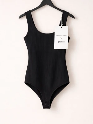 Ribbad svart body från Gina Tricot - Snygg svart body i ribbat material från Gina Tricot x Maja Nilsson Lindelöf. Modellen har breda axelband, rundad halsringning och knäppning i grenen. Perfekt att styla med jeans eller kjol för en clean look.