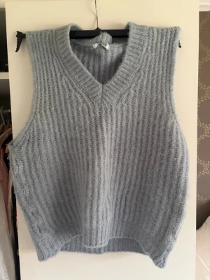 Ljusblå stickad väst med v-ringning - Ljusblå stickad väst från design by si. Använd en gång 