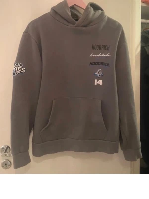 Hoodrich  - Säljer ett par klassiska blå bootcut jeans med fem fickor och normalhög midja. Jeansen har en snygg tvätt och är tillverkade i denim med kontrastsömmar. Perfekta för dig som gillar en retroinspirerad look och vill ha ett par jeans med lite vidare ben.