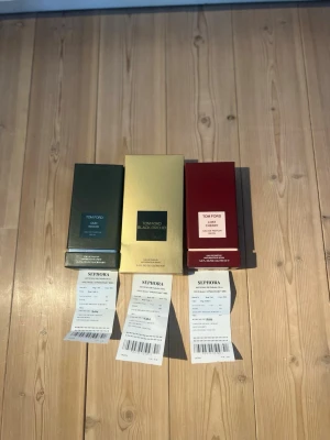 Tom Ford parfym reseller bundle - Säljer tre exklusiva parfymer från Tom Ford: Oud Wood i grön förpackning, Black Orchid i guldig förpackning och Lost Cherry i röd förpackning. Alla kommer i sina snygga originalkartonger och är perfekta för dig som vill ha lyxiga dofter.