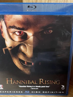 Hannibal Rising Blu-ray - Blu-ray-utgåva av filmen Hannibal Rising. Omslaget är blått och filmen är en thriller med engelskt tal och svensk text. Baksidan har beskrivning på flera språk och bilder från filmen. Perfekt för dig som gillar spännande och mörka berättelser.