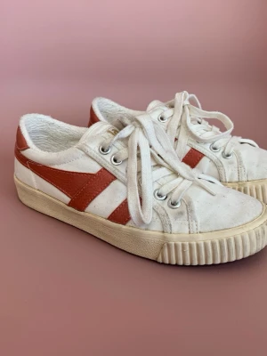 Vita Gola sneakers 36 - Snygga Gola vita sneakers med röda läderdetaljer på sidorna och vita snören. 