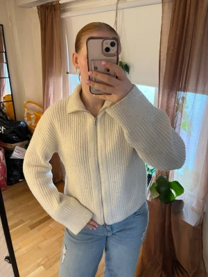  stickad ziptröja - Mysig vit stickad tröja med dragkedja framtill. Från bikbok. Tröjan är lite nopprig men annars fin 