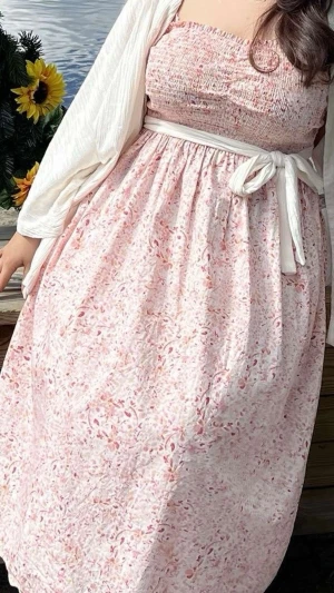 Blommig sommarklänning - Söt ljusrosa klänning med tunna axelband. Klänningen har ett diskret blommönster i rosa och vitt. Perfekt för sommarens varma dagar och har en luftig, avslappnad passform. Klänningen har inga skador alls, den är använd bara ett par gånger. 