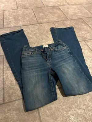 Blå bootcut jeans från ONLY - Säljer ett par blå bootcut jeans från ONLY. normalhög midja och stretchigt material, säljs pågrund av ingen användning 💓