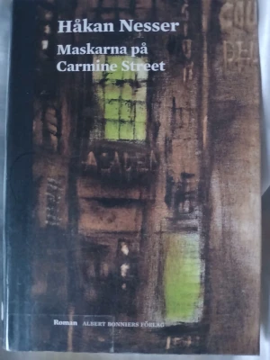 Maskarna på Carmine Street - En roman av Håkan Nesser med ett omslag i mörka toner och gröna inslag. Boken har hård pärm och titeln är tryckt i vitt på både framsidan och ryggen. Perfekt för dig som gillar spännande och välskriven skönlitteratur. Köpt från ett bibliotek men mycket fint skick.
