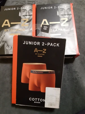 A–Z by Zlatan orange kalsonger 2-pack Helt nya  - Junior 2-pack boxerkalsonger från A–Z by Zlatan i en snygg orange färg med svart resår och gul text. Tillverkade i mjuk bomull för maximal komfort. Perfekta för dig som vill ha stilrena och bekväma underkläder. Helt nya, aldrig använda. 80 kr/ förpackning. 