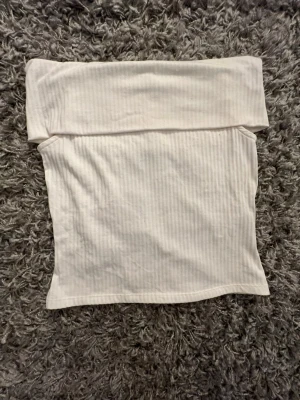 Vit ribbad offshouldertopp - Säljer en enkel och stilren vit offshoulder topp med ribbad struktur. Storlek M från Pieces. Perfekt att matcha med jeans eller kjol för en clean look. Skriv om du undrar något💕