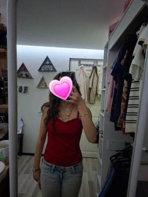 Röd boddy med smala axelband - Snygg röd boddy med smala axelband. Toppen är figurnära och har en enkel, stilren design som passar perfekt till jeans eller kjol. Materialet känns mjukt och följsamt mot kroppen. Använs endast nån gång.