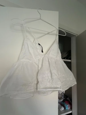 Vit broderad linnetopp med spets - Säljer denna söta topp pga att den är för stor på mig. Använt ett fåtal gånger. Passar perfekt på sommaren. Frakt tillkommer