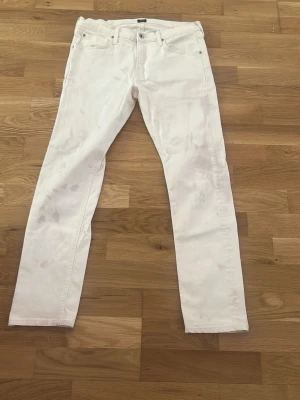 Vita raka jeans från Lee - Snygga vita jeans från Lee med klassisk rak passform. Jeansen har fem fickor, bälteshällor och stängs med knapp och dragkedja. Perfekta för en fräsch och stilren look. Materialet är bomull för en bekväm känsla.