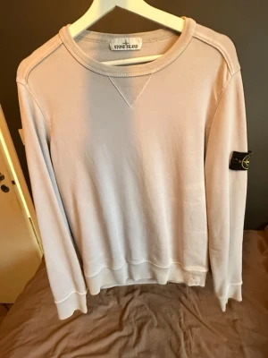 Beige sweatshirt från Stone Island - Lila/Beige Stone Island sweatshirt perfekt till sommaren. Säljer då den inte längre kommer till användning. Billigt pris då jag är osäker om den är äkta eller inte. 