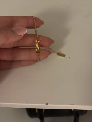 Guldfärgat armband från Saint Laurent - Snyggt och stilrent armband i guldfärgad metall! Skriv privat for fler bilder!