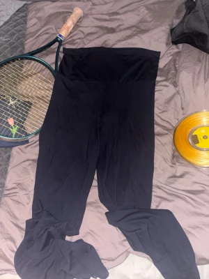 Mörklbkåa  höga leggings - Säljer ett par mörklblå yoga pants med hög midja, vickbar . De är mjuka och stretchiga, perfekta för en chill och bekväm stil. Materialet känns som bomull eller viskosblandning och de har en enkel, clean look utan synliga detaljer eller loggor.