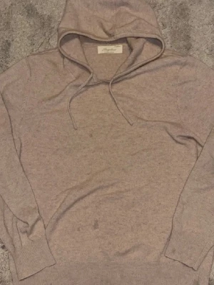 Beige hoodie från sayless - Mysig beige hoodie från sayless med klassisk huva. Tillverkad i mjukt material som känns skönt mot huden. Perfekt för en avslappnad och stilren look. Långa ärmar och ribbade muddar för extra komfort.
