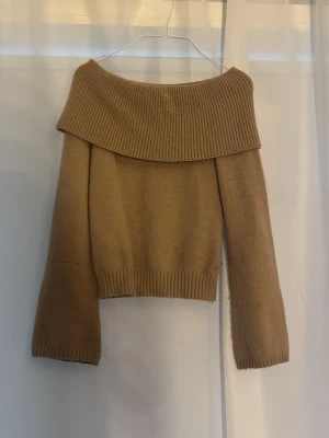 Stickad Beige off shoulder stickad tröja - Stickad biege off shoulders tröja med utsvängda armar. Den är verkligen bästa tröjan på vinern och rö super söt på. ( obs att den är något nopprig och en söm på armen som syns i bilden) på den högra armen💗