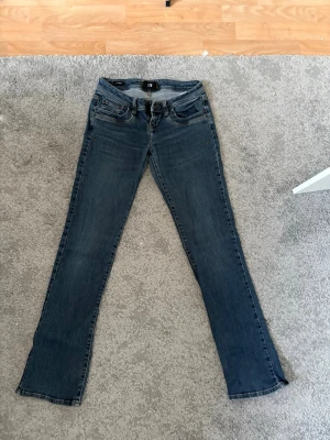Blå bootcut jeans från LTB - Säljer ett par klassiska blå bootcut jeans från LTB, modell Valerie. Jeansen har fem fickor, normalhög midja och dragkedjegylf. Tillverkade i stretchigt denim för skön passform och snygg tvättad look. Nypris är 900