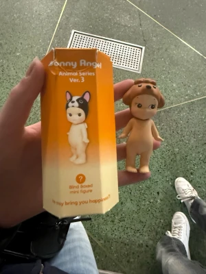 Sonny Angel Animal Series Ver. 3 figur - Säljer enkelt ny söt minifigur från Sonny Angel Animal Series Ver. 3. Figurinens huvud har en brun hundmössa och kroppen är beige. Perfekt som samlarpryl eller dekoration. Kommer i originalförpackning.