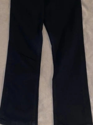 Svarta raka jeans från Produkt - Svarta jeans från Produkt med rak passform och klassisk femficksdesign. Jeansen har normal midja och är tillverkade i ett mjukt denimtyg. Perfekta för en stilren och enkel look. Storlek 32L och 32W. 