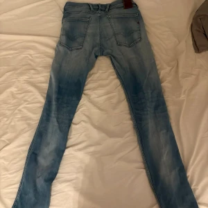 Ljusblå slim fit jeans Replay - Snygga ljusblå slim fit Replay jeans med slitningar och stora framfickor. Jeansen har en klassisk femficksdesign och är tillverkade i denim. Perfekta för en avslappnad och trendig look.