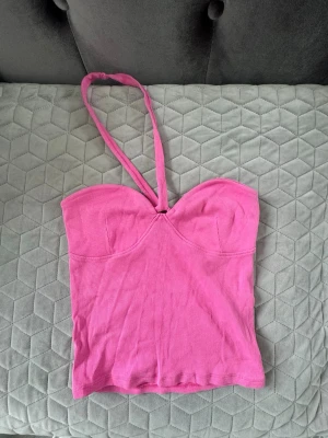 Rosa ribbad halterneck topp - Snygg rosa ribbad halterneck topp. Toppen är croppad och har en figurnära passform, perfekt till sommarens outfits.
