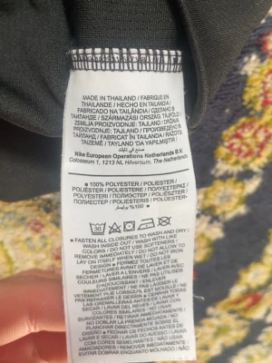 Svart löpartröja Nike Dri-FIT - Svart löpartröja från Nike med Dri-FIT-teknologi. Tröjan har dragkedja framtill, tryckt Nike Running-detalj i kragen och är tillverkad i 100% polyester för bra andningsförmåga. Perfekt för löpning och träning.