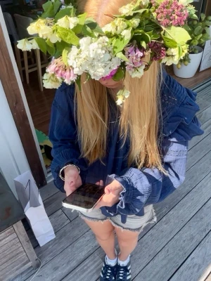 Mörkblå volangblus med v-ringning - Snygg mörkblå blus med v-ringning och volangdetaljer vid axlar och ärmslut. Blusen har lång ärm och är tillverkad i ett lätt, krinklat tyg som ger en avslappnad känsla. Perfekt att styla med jeans eller kjol för en trendig look.