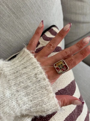 Ring med knapp - Säljer denna handgjorda ring.  Knapparna är vintage men själva ringen/ringstommen är helt ny och oanvänd. Materialet är rostfritt stål och varken tappar färg eller färgar av sig på huden. Ringen tål vatten. Storleken är justerbar, man kan trycka ihop och dra isär ringen till önskad storlek. Perfekt för dig som vill bära något unikt!