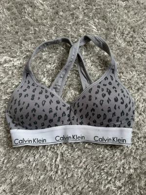 Leopardmönstrad bh från Calvin Klein - Snygg grå bh från Calvin Klein med leopardmönster och korsade axelband. Pris kan alltid diskuteras!