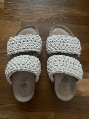 Beige flätade sandaler  - Snygga sandaler från Duffy i beige med två breda, flätade band i textil. Använda ett fåtal gånger och är därför nästan i nyskick. Perfekta för en avslappnad och trendig look i sommar (nypris 600) 