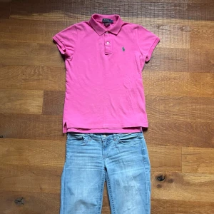 Ralph Lauren Piké Dam Small Rosa - Fin rosa Ralph Lauren piké med grön logga. Supertrendigt med preppy/old money-stilen just nu och färgen sticker ut snyggt 🌸 Passar perfekt till lågmidjade jeans, linnebyxor eller kjol för en clean och feminin look.                                                                Kommer från ett rökfritt hem.                             Snabb leverans 📦                                  