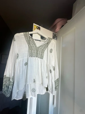 Vit blus med grönt mönster Zara - säljer min blus från zara jätte bra skick och använd 3-4 gånger. Passar perfekt med en kjol eller ett par jeans. 