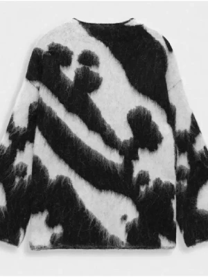 Stickad tröja med svartvitt mönster - Fluffig stickad tröja i svart och vitt med abstrakt mönster. Tröjan har rund halsringning och långa ärmar. Materialet ser ut att vara en mjuk och lurvig ullblandning som ger en cool och trendig look. Prislappen sitter kvar på tröjan!! Aldrig använd. Storlek S.