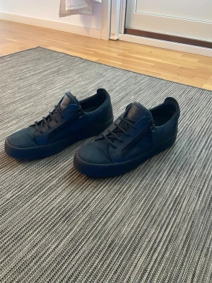 Giuseppe Zannoti sneakers - Snygga mörkblå giuseppes med den klassiska dragkedjan på sidorna och snörning framtill. Skorna har en stilren design i mocka och läder. Riktigt bra kvalité på dessa skor och säljer de billigt för jag inte använt dom på länge. Har ingen sko box eller något sånt då de va länge sen jag köpte de. Skicket är helt okej, bara att det är lite slitna i sulan