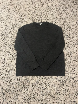 Mörkgrå stickad tröja från Arket - En enkel och stilren mörkgrå stickad tröja från Arket. Tröjan är i mycket bra skick och använd fåtal gånger.