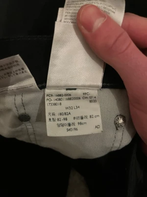 Svarta Levi's 501 jeans W32 L34 - Säljer ett par klassiska svarta Levi's 501 jeans med raka ben och fem fickor. Jeansen har den ikoniska röda Levi's-lappen på bakfickan och svart patch bak i midjan. Tillverkade i slitstarkt denimtyg, perfekta för en clean och tidlös look.