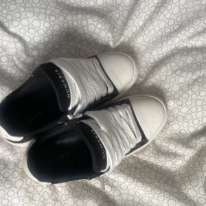 Numeris  - Snygga sneakers från Numeris i svart och vitt. Skorna har vita snören, svart insida och detaljer samt vit tå och sula. Klassisk låg modell med stilren design och text på plösen. Perfekta för en trendig och avslappnad look.