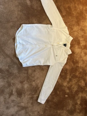 Vit skjorta från Ralph Lauren - Klassisk vit skjorta från Ralph Lauren med lång ärm och knappar framtill. Skjortan har en liten broderad logga på bröstet och är tillverkad i mjuk bomull. Perfekt för en clean och stilren look.hör av er för fler bilder eller frågor😁