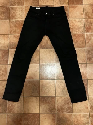 Svarta Levi's jeans i bomull - Snygga svarta jeans från Levi's med klassisk femficksmodell och raka ben, i storlek W29 L32.  Påse tillkommer även tags! Kan bytas mot en likadan men i gamla modellen d.v.s gula lappen och inte svarta