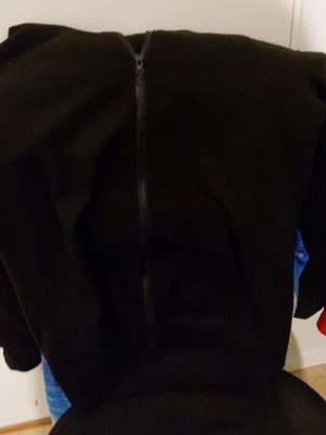 Svart hoodie med dragkedja - En klassisk svart hoodie med dragkedja framtill och huva. Perfekt för en avslappnad och stilren look. Tillverkad i mjukt material som känns skönt mot huden. Passar lika bra till jeans som till mjukisbyxor.