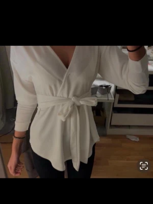 Vit omlottop - Vit omlottopp från Boohoo med knytdetalj i midjan 🤍 Superfin passform som sitter smickrande och ger en clean, trendig look. Perfekt till både vardag, fest eller utekväll – lätt att styla upp eller ner. Pris kan diskuteras 🤍