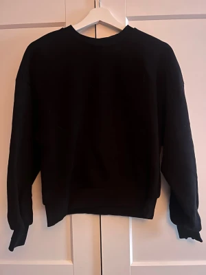 Svart sweatshirt - En enkel svart sweatshirt med rund hals och långa ärmar. 